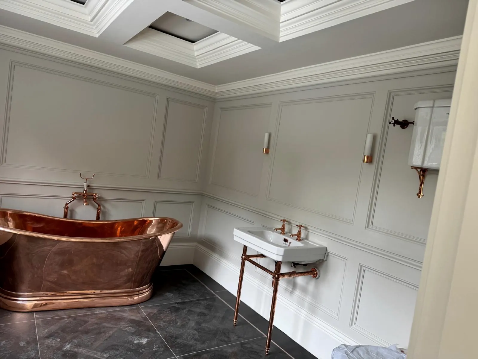 Panelled bathroom with a copper roll-top bath